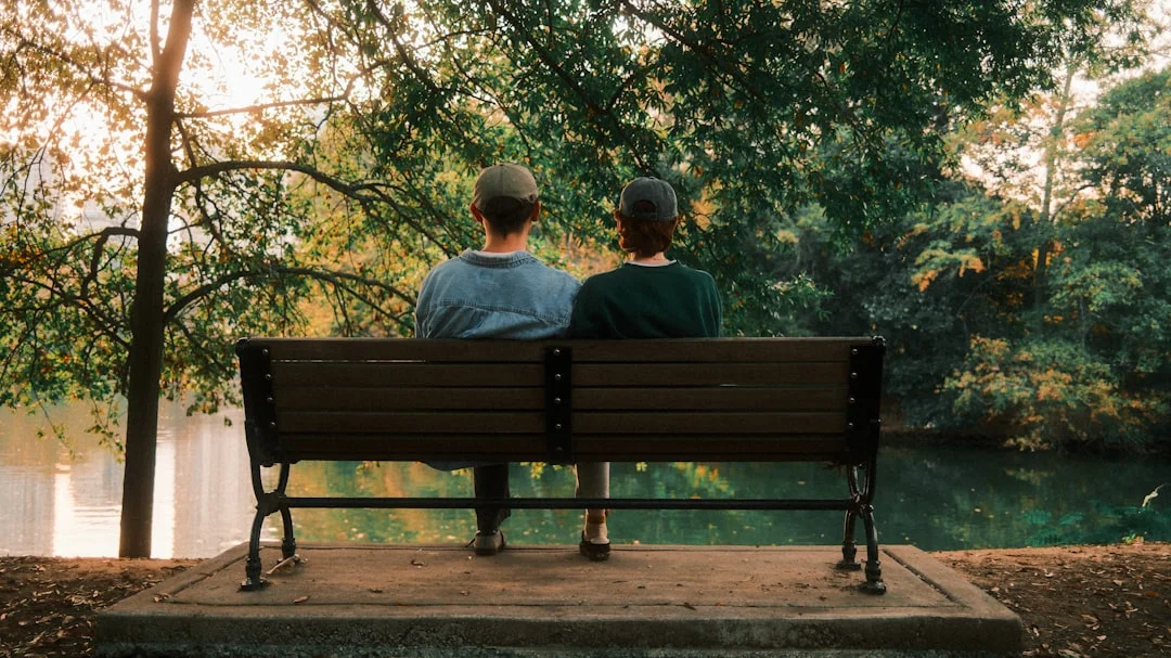 情侶坐在公園長椅上聊天,享受戶外自然時光
